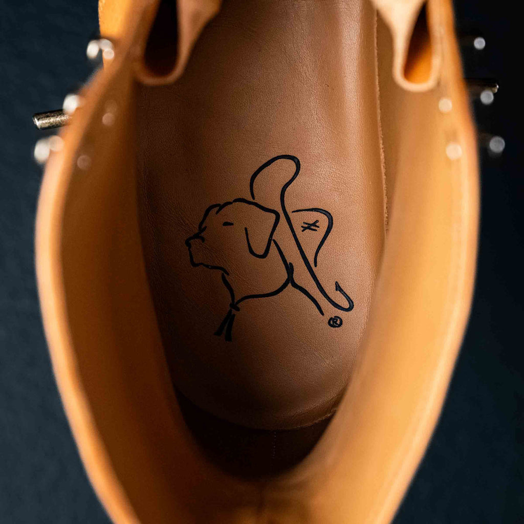 Inside view of a high quality English tan leather Officer's Boot showing the leather insole with the Saddleback dog logo