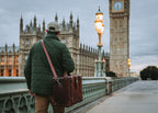 Grandfather Carry On in Chestnut on a shoulder strap, carried by a man walking toward Big Ben in London
