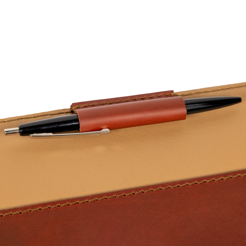 Old Design Medium Leather Portfolio in Chestnut, close-up of the leather pen loop holding a pen