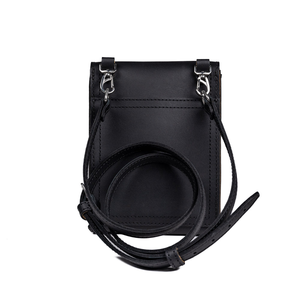 Leather Travel Satchel in Black, back view with removable shoulder strap clipped to swivel hooks