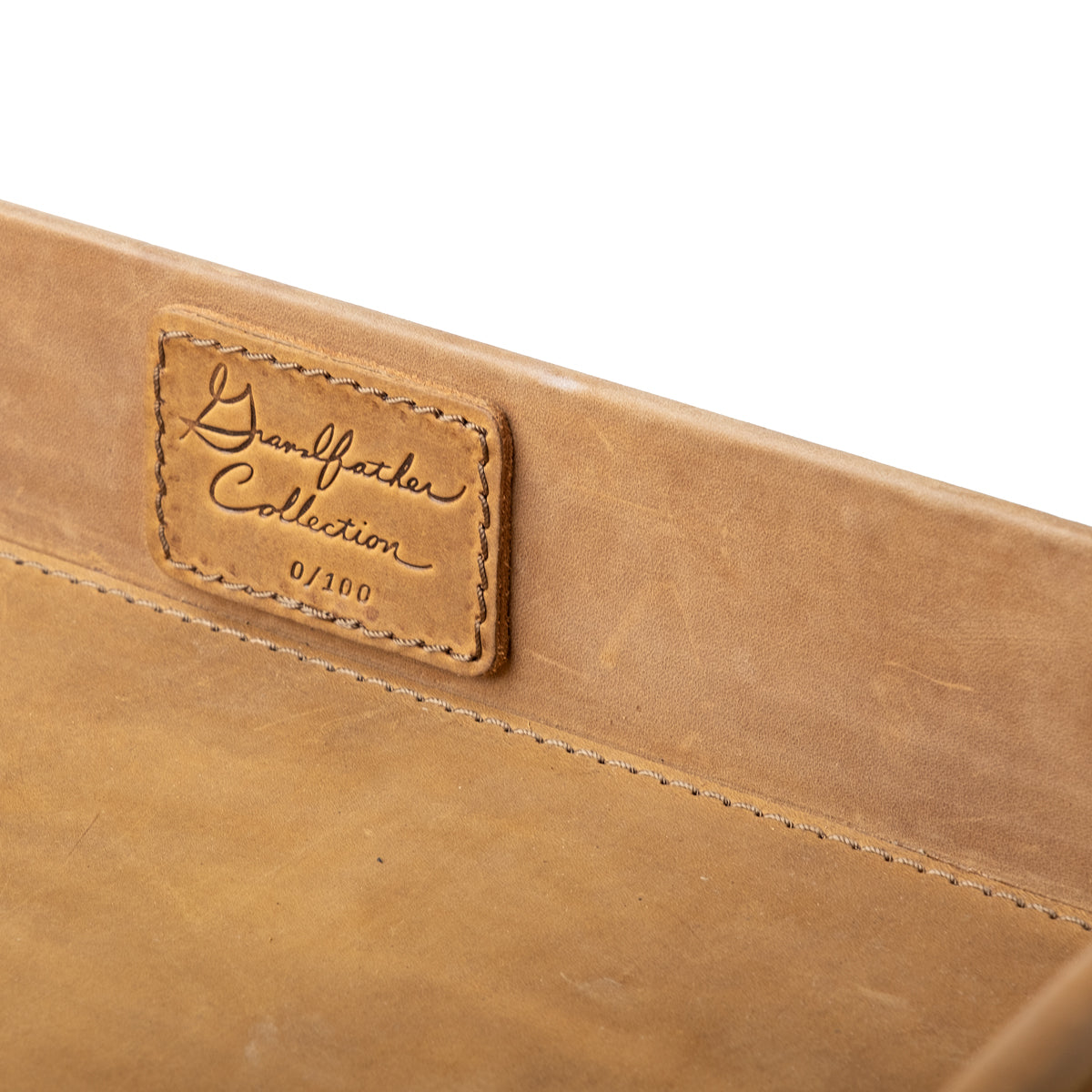 Grandfather Serving Tray in Tobacco leather, close-up of stitched Grandfather Collection patch on the inner wall