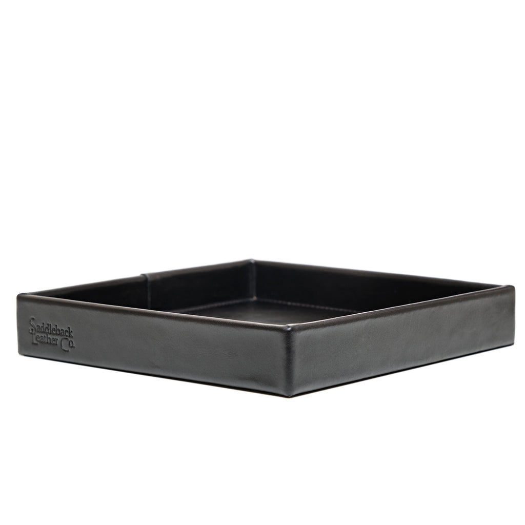 The Simple Leather Valet Tray in Black, empty, low side view with embossed logo on the front edge