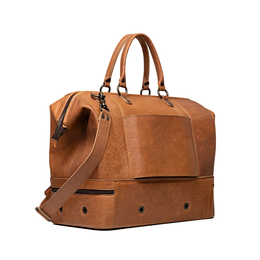 Two Compartment Duffle in Tobacco, angled back view with trolley sleeve and vented bottom compartment