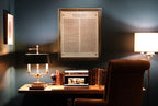 Leather Magna Carta - Natural in a wood frame on a home office wall above a desk with lamp, books and laptop