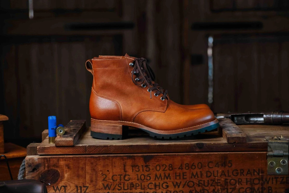 Huntsman Boots - Natural, side profile of a pair on a stenciled wooden crate in a rustic cabin
