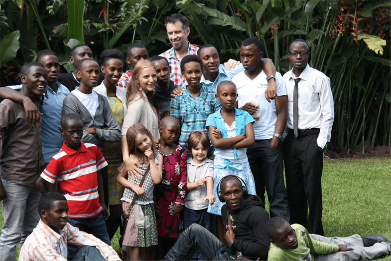 Dave and Suzette with their Rwandan sons and daughters gathered on a lawn.