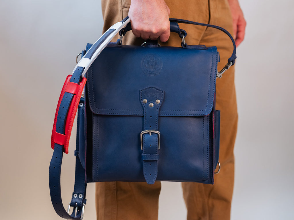 Saddleback Club Membership Paul Revere Leather Messenger Bag Backpack in Red, White and Blue, carried by its top handle
