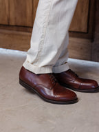 Toe Cap Shoes in Dark Oak, side view of the pair worn with cuffed cream trousers