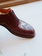 Wingtip Shoes in Chestnut, close-up of brogue toe cap, dark laces and welt stitching