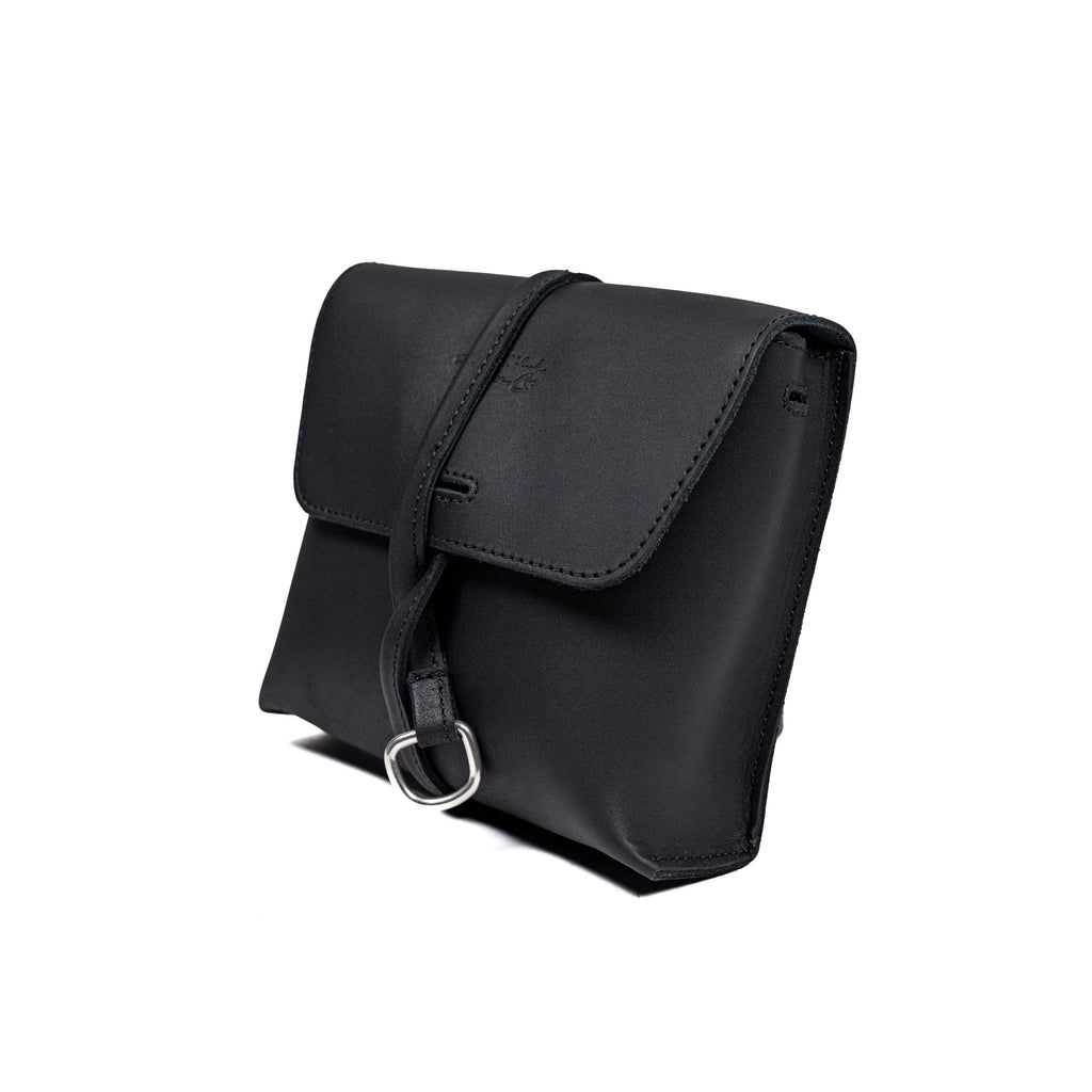 Leather Organizer Bag in Black, three-quarter view with flap closure and strap wrapped around the front