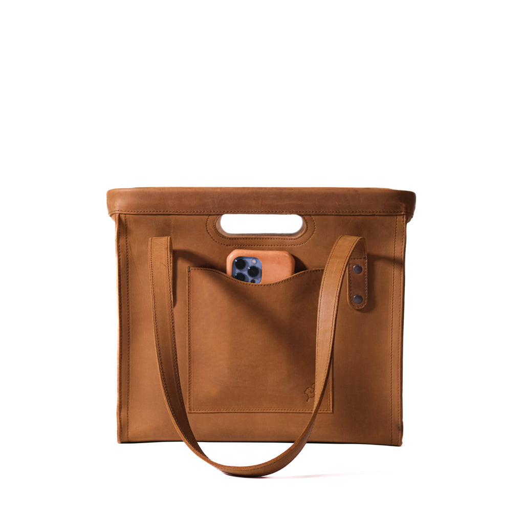 Professional Leather Tote in Tobacco, front view with handles lowered, cutout grip and a phone in the front pocket