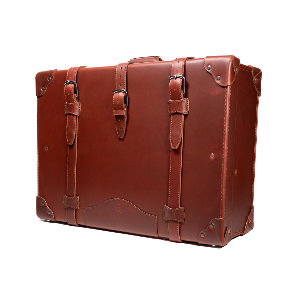 Grandfather Suitcase in Chestnut, angled front view with buckle straps and riveted corner caps