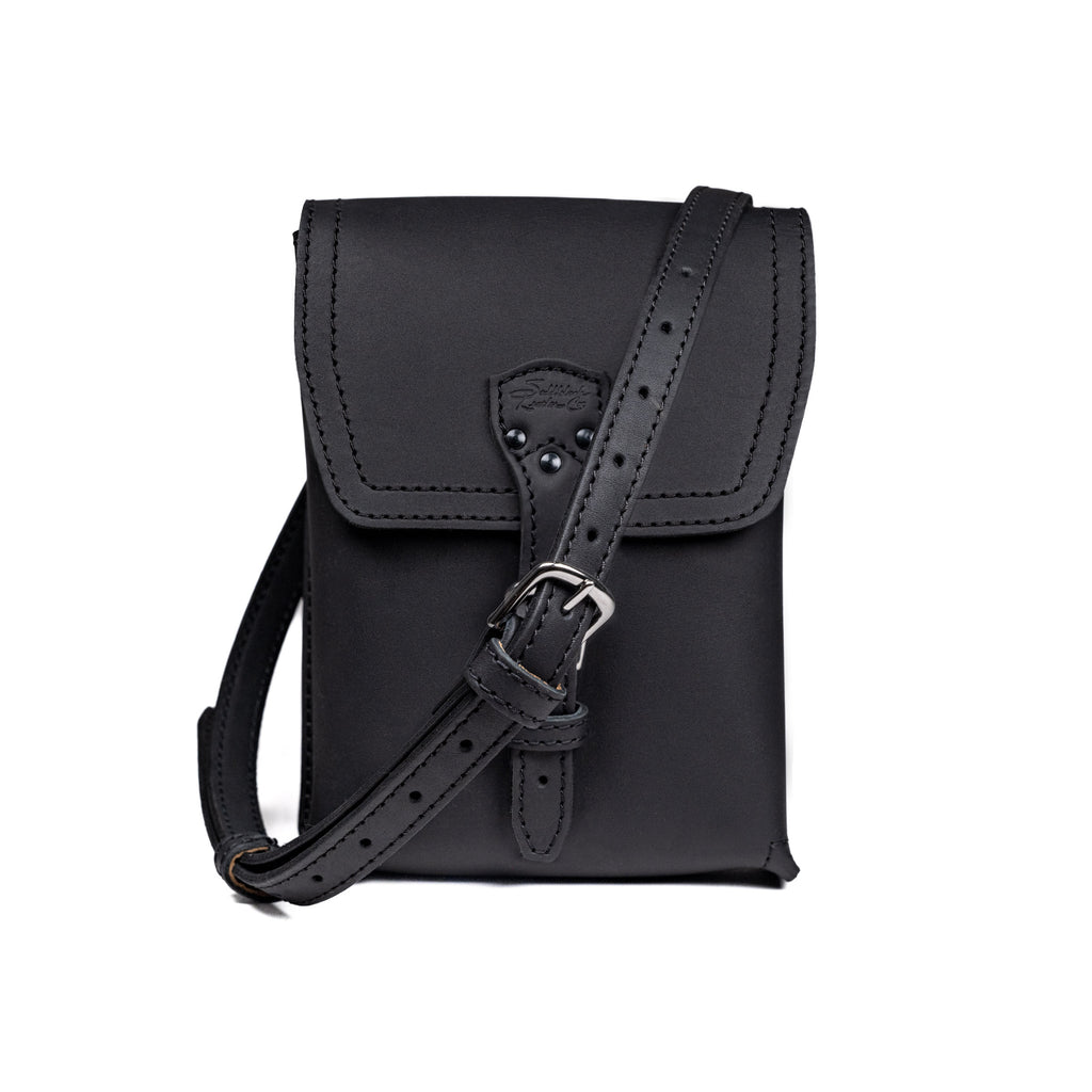Leather Travel Satchel in Black, front view with adjustable shoulder strap draped across the bag