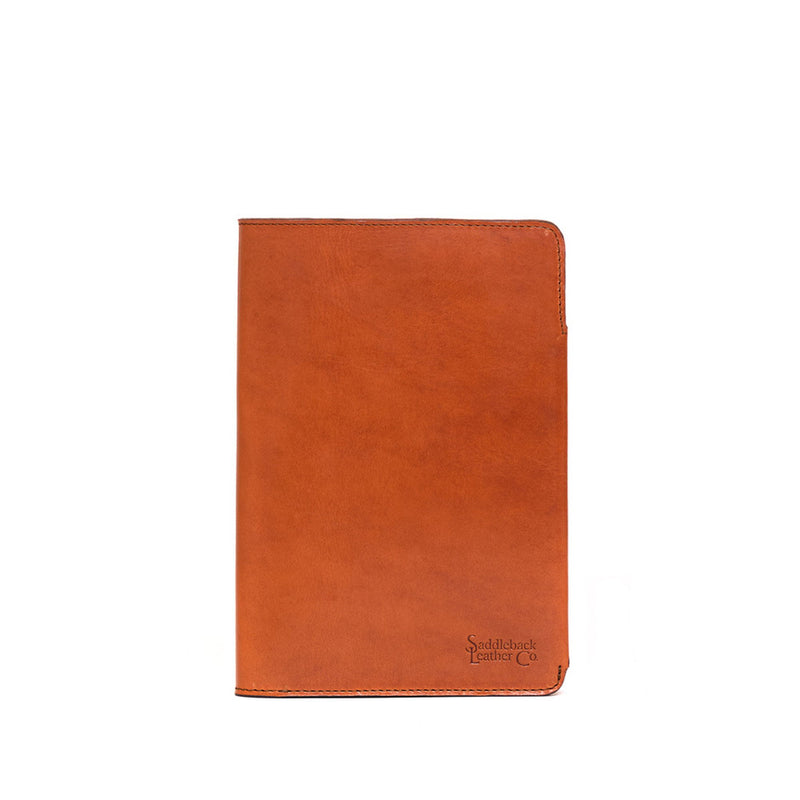 Plain tan leather journal cover, closed, with a logo embossed near the lower corner.