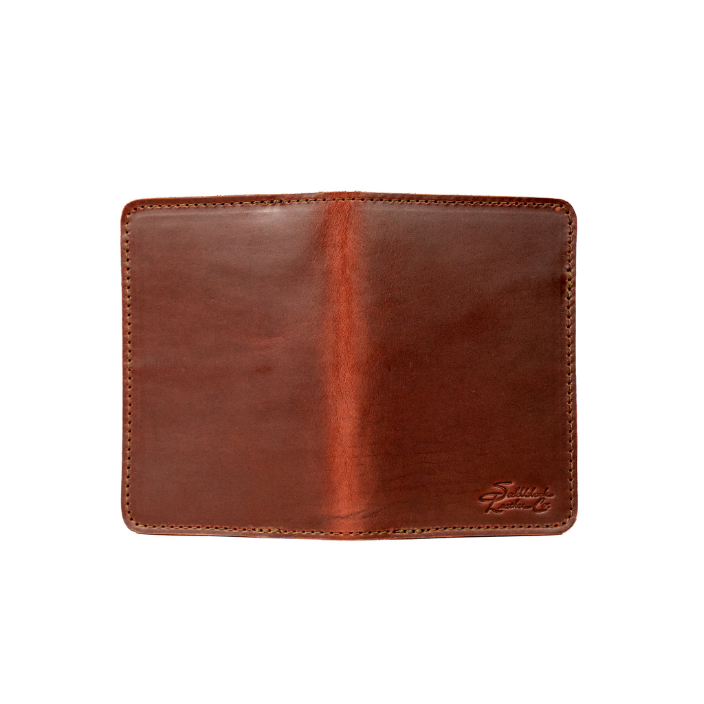 Slim Passport Wallet in Chestnut opened flat face down, showing the full outer cover and embossed logo