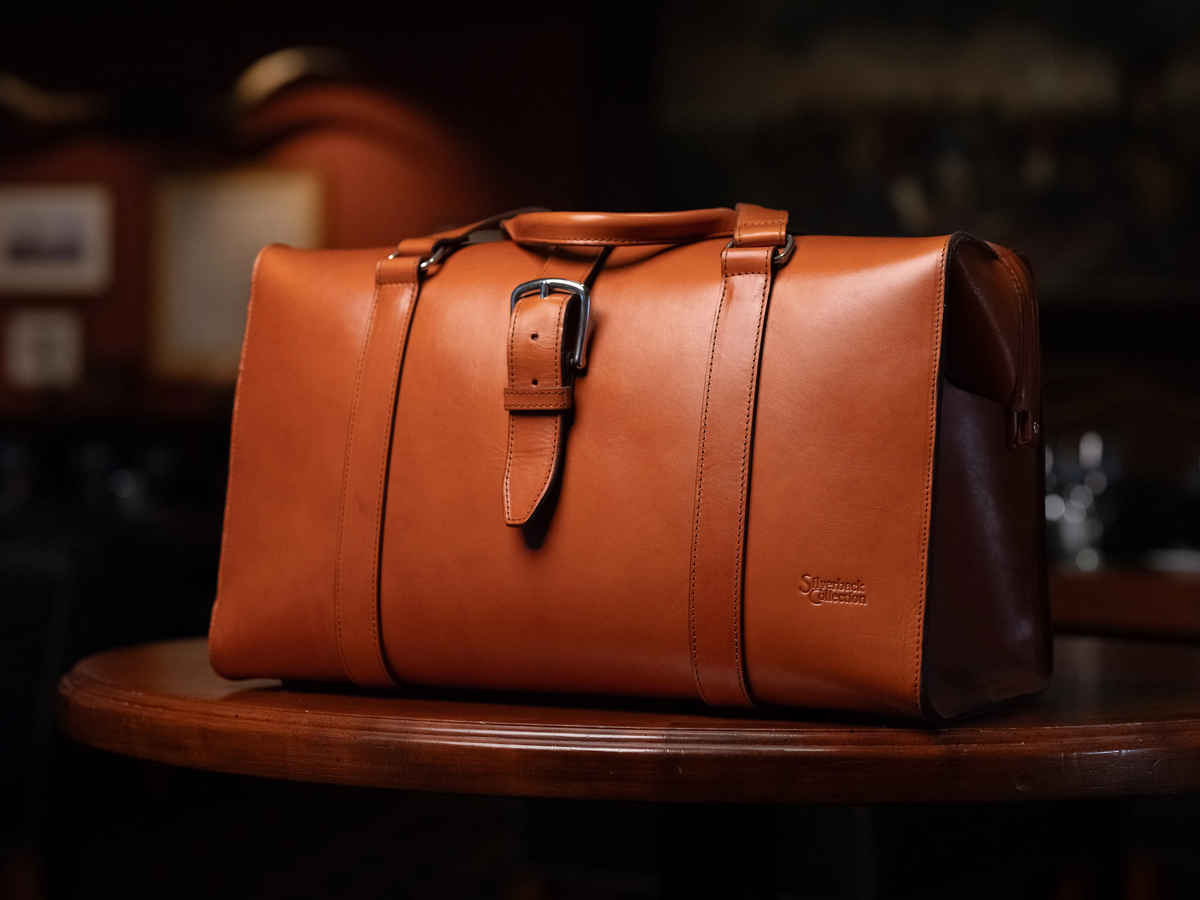 Taylor Leather Doctor's Duffle in Natural on a wooden table in a dimly lit room