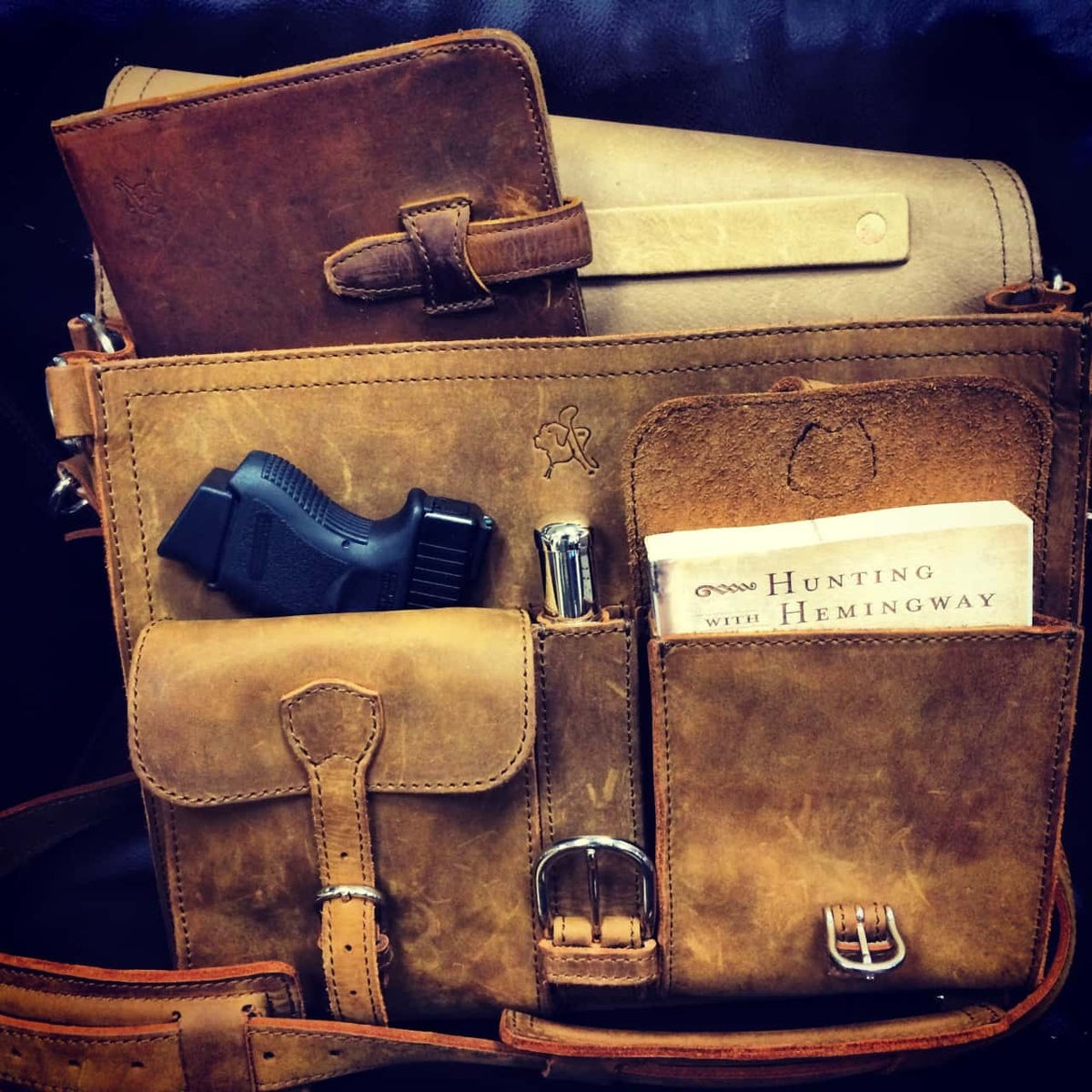 Thin Front Pocket Leather Briefcase in Tobacco, close-up of the front pockets loaded with a journal, flashlight and book