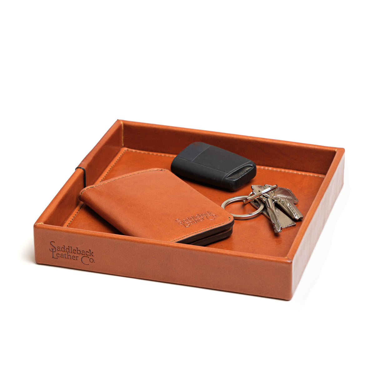 The Simple Leather Valet Tray in English Tan holding a leather card wallet, key fob and keys, angled view