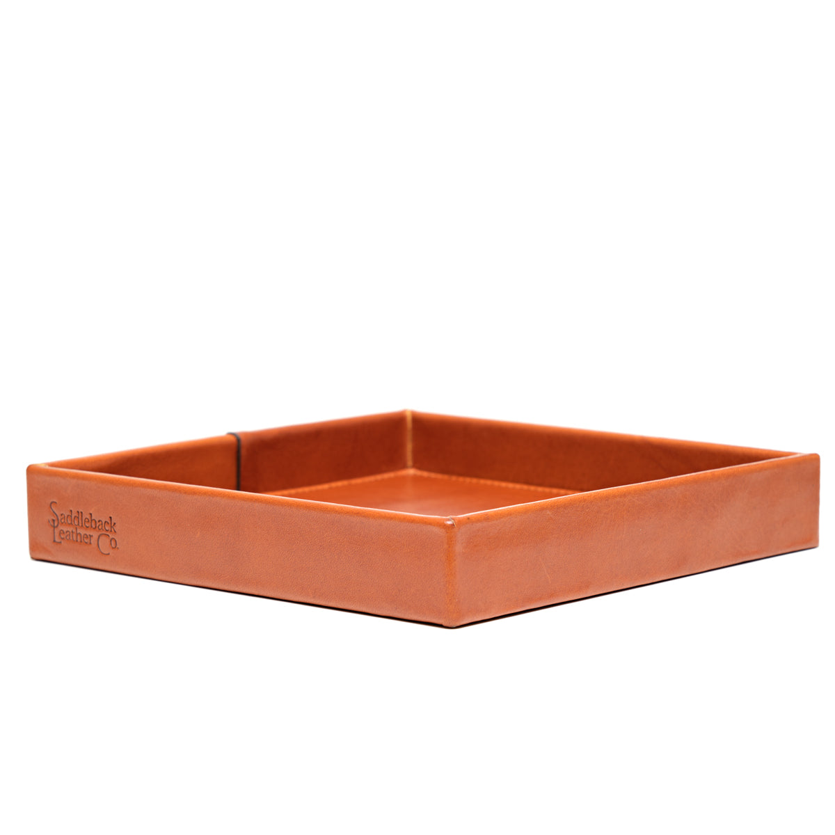 The Simple Leather Valet Tray in English Tan, empty, low side view with embossed logo on the front edge