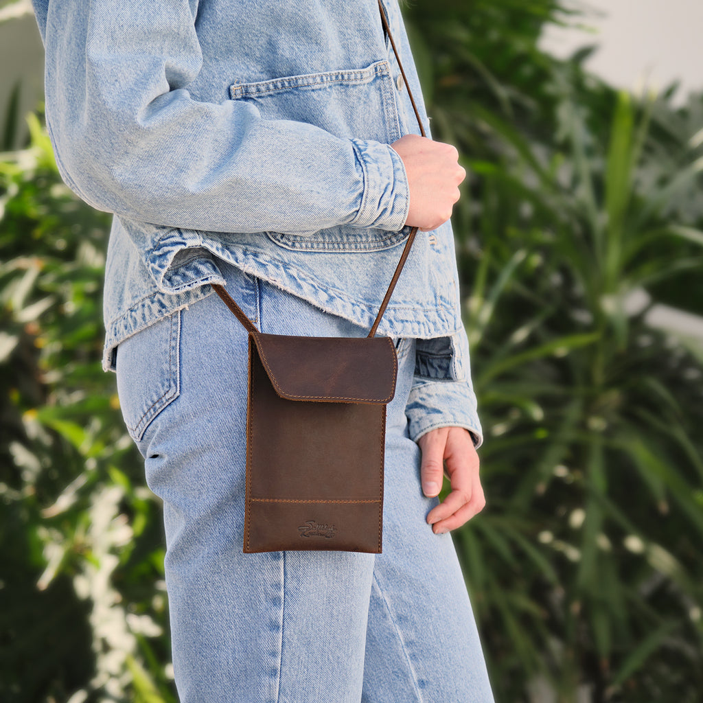 Walker's Pouch in dark brown, worn crossbody at the hip with a denim jacket and jeans