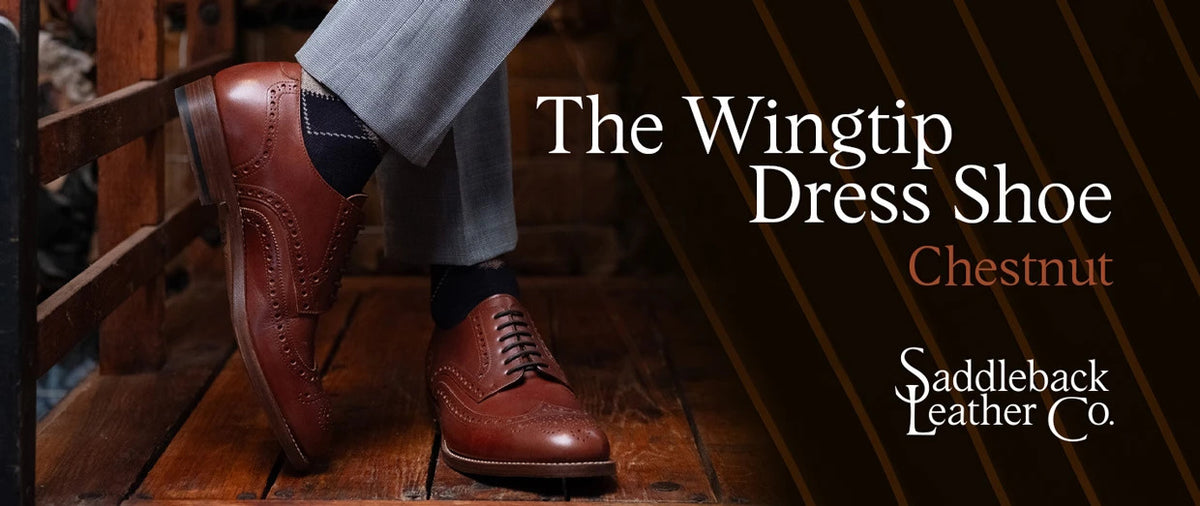 Wingtip Shoes - Chestnut worn with crossed legs on rustic wood, banner text The Wingtip Dress Shoe Chestnut